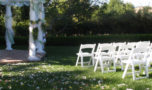 White chairs set for an outdoor ceremony at Oak Hill